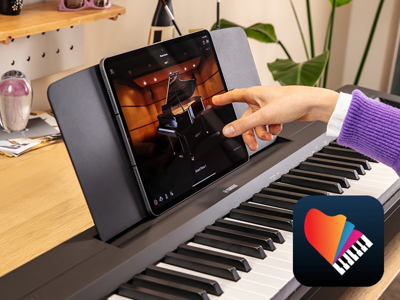 The Yamaha “Smart Pianist” app icon, together with a tablet placed on the music stand of the P-145BT