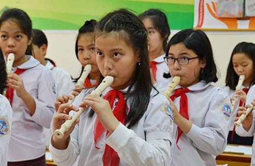 Primary school students performing in music club activities in Vietnam