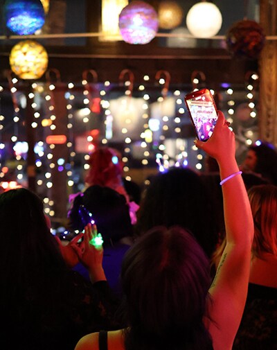 Audience member using a smartphone to capture highlights of a live performance for social media.