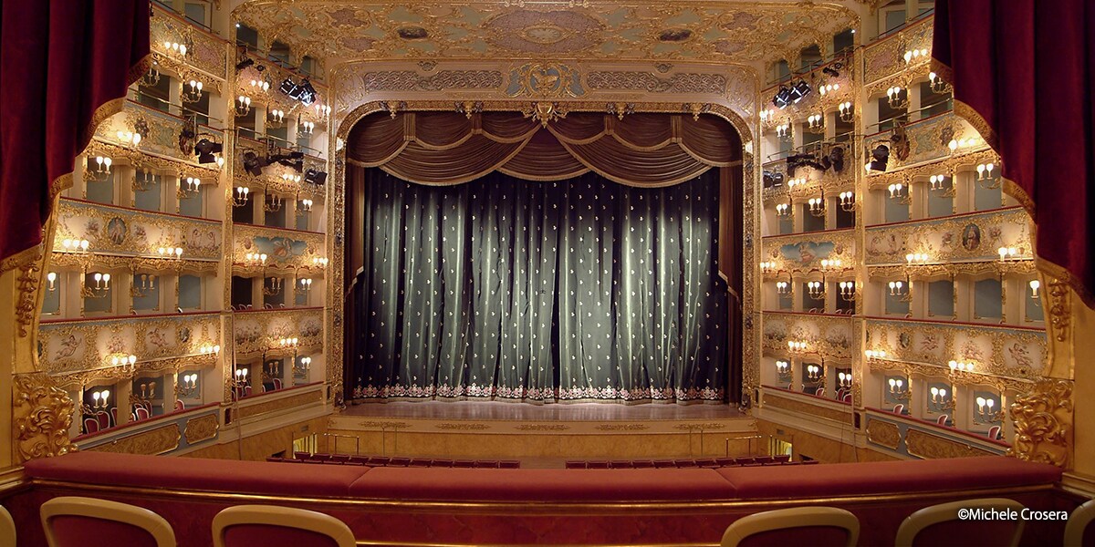 Interior view of Teatro La Fenice opera house, showing the ornate auditorium, stage, and seating from the audience perspective.